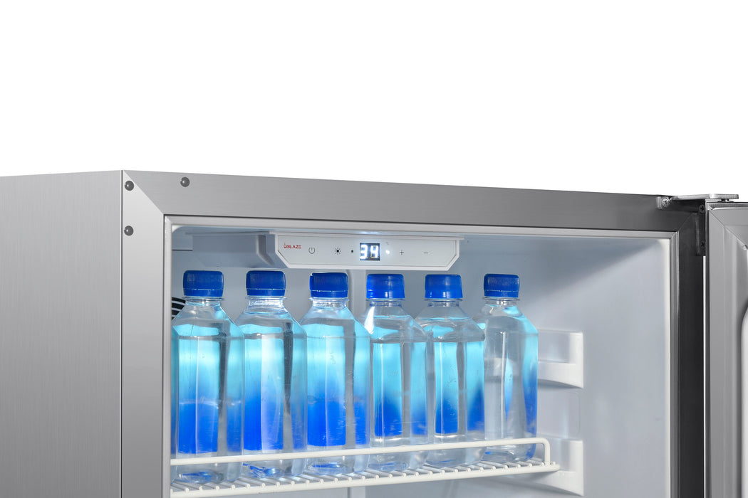 Stono Outdoor Living A close-up of an open Blaze 20-Inch 4.3 Cu. Ft. Outdoor Rated Refrigerator w/ Lock (BLZ-SSRF20-4.3) on a BBQ island displays six clear water bottles on a wire shelf, with an electronic display above showing 3.9°C.
